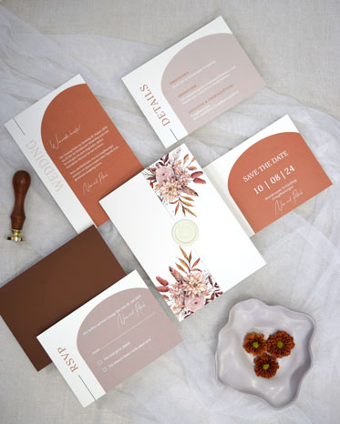 Flatlay mit einer Hülle im Altarfalz, Wachssiegel und Save The Date Karte in Beige und Braun